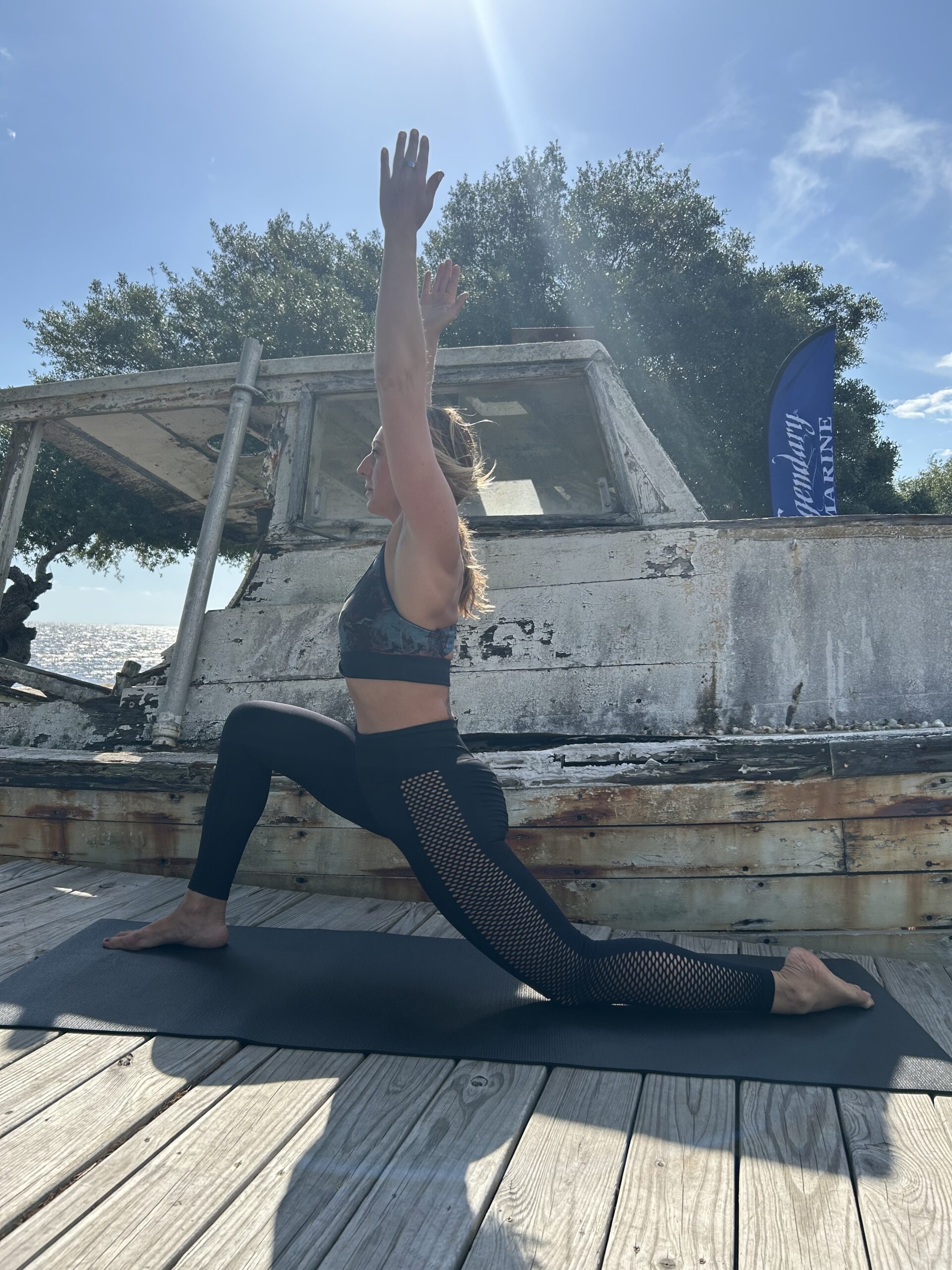 Kristina Morros performing a yoga lunge pose on Redneck Beach near Nick's Seafood Restaurant in Freeport, Florida.